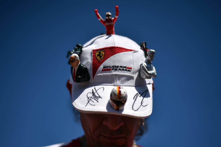 I cappellini non mancano mai sulla testa degli appassionati della Ferrari... (Afp)